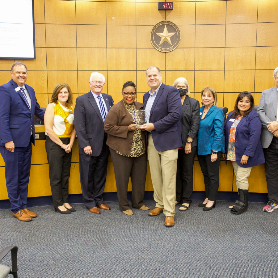 Board of trustees and community members pose with award